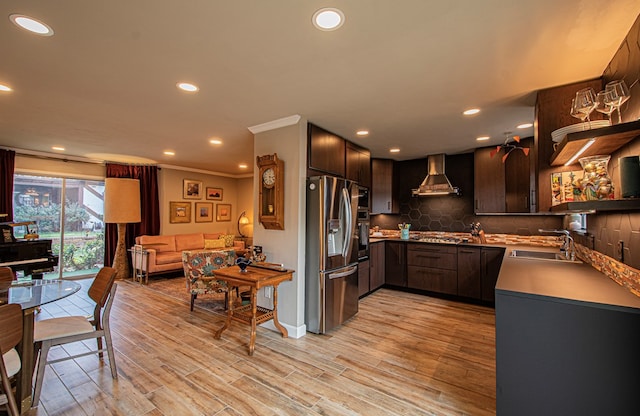 kitchen with sink, wall chimney exhaust hood, stainless steel appliances, crown molding, and light wood-type flooring