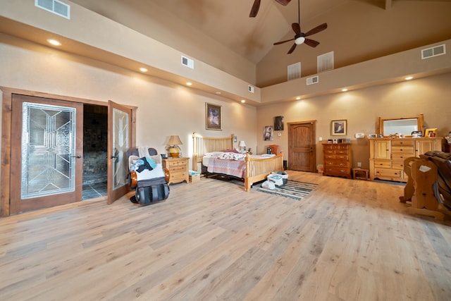 bedroom featuring high vaulted ceiling and light hardwood / wood-style floors