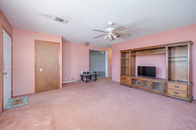 unfurnished living room featuring carpet flooring, a textured ceiling, and ceiling fan