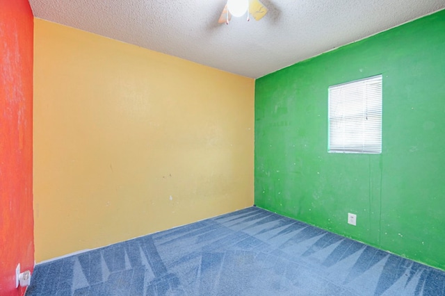 carpeted empty room with a textured ceiling and ceiling fan