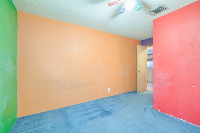 spare room with ceiling fan, carpet floors, and a textured ceiling