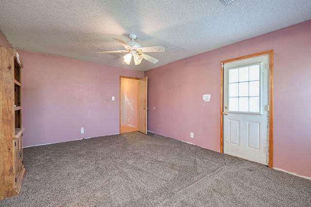 empty room with ceiling fan, carpet floors, and a textured ceiling