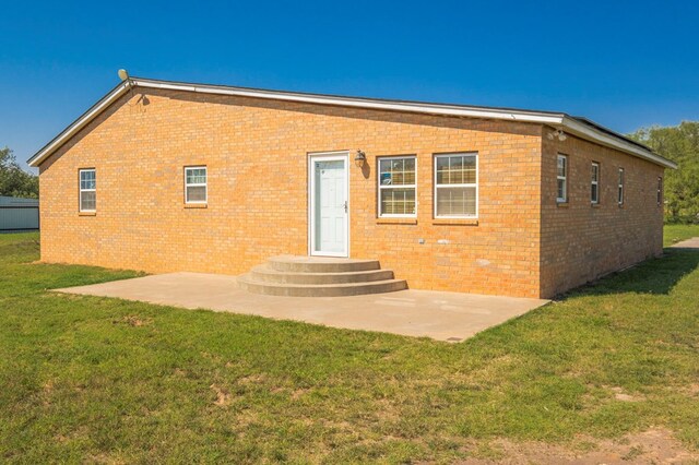 back of property featuring a yard and a patio