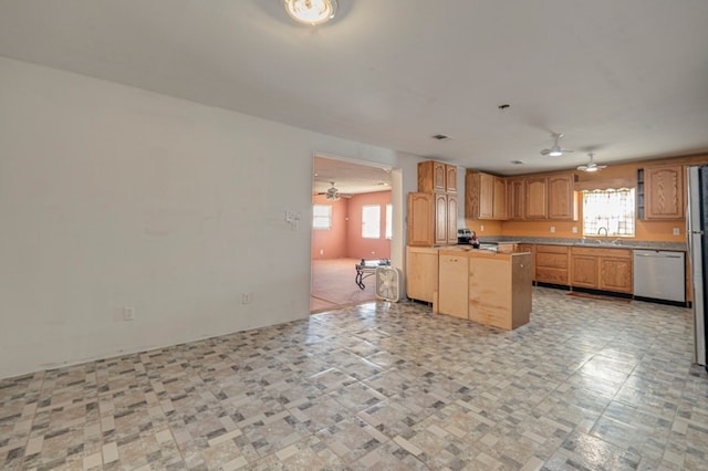 kitchen featuring plenty of natural light, ceiling fan, sink, and stainless steel appliances