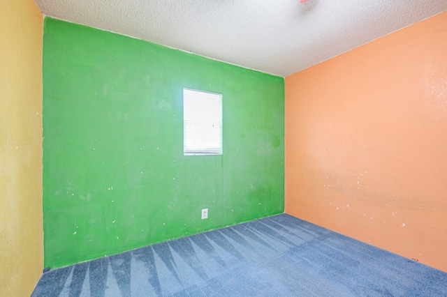 empty room with carpet and a textured ceiling