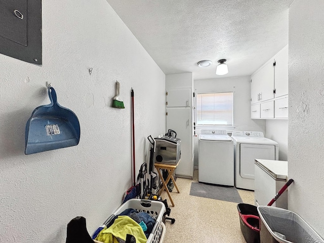 washroom with a textured ceiling, a textured wall, separate washer and dryer, and cabinet space