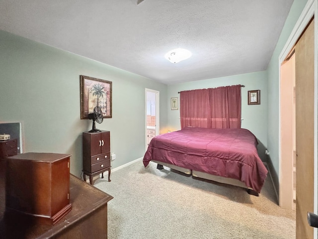 bedroom featuring a textured ceiling, carpet, and baseboards