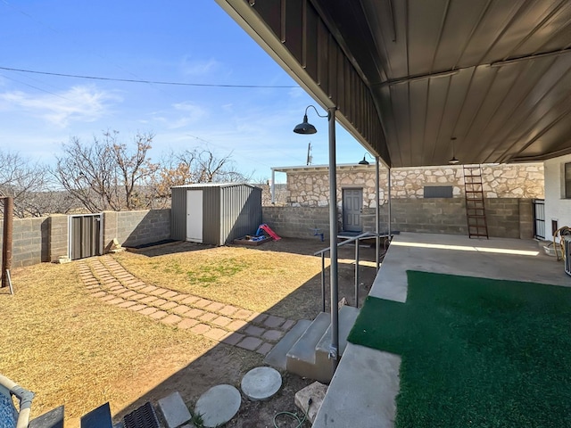 view of yard featuring a storage shed, a patio, an outdoor structure, and a fenced backyard