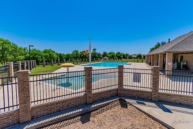 community pool with fence and a patio
