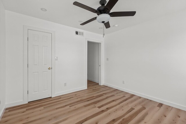 empty room with ceiling fan and light hardwood / wood-style flooring