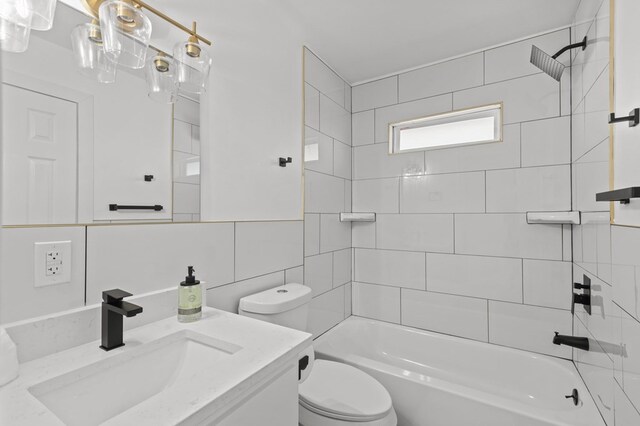 full bathroom with vanity, tiled shower / bath, decorative backsplash, toilet, and tile walls