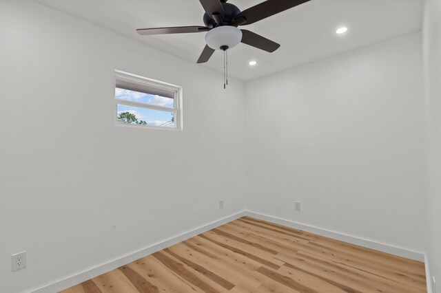 empty room with hardwood / wood-style floors and ceiling fan