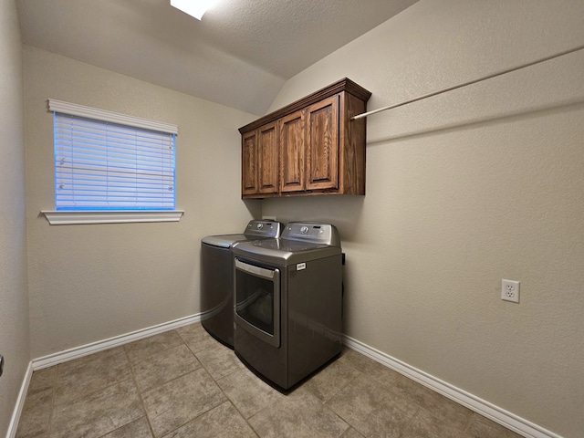 laundry area featuring baseboards, washer and clothes dryer, cabinet space, and light tile patterned floors