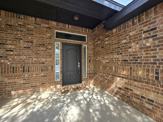 entrance to property featuring brick siding