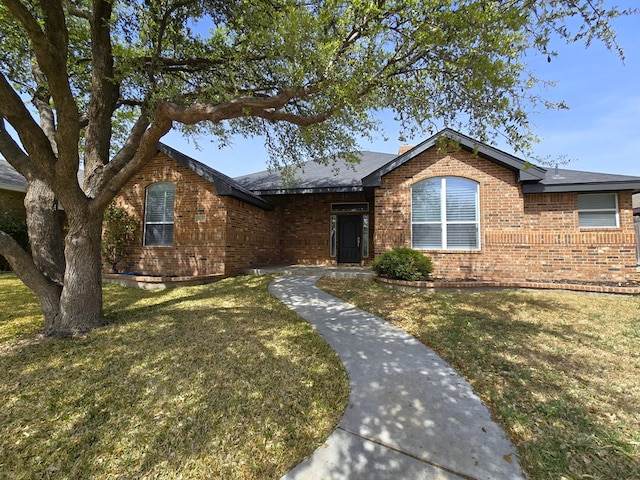 ranch-style home with a front lawn and brick siding