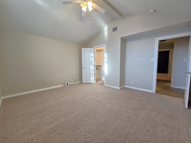 unfurnished bedroom with visible vents, baseboards, carpet floors, and vaulted ceiling with beams