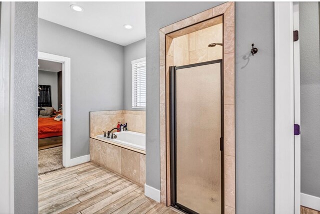 bathroom featuring hardwood / wood-style floors and shower with separate bathtub