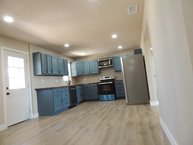 kitchen with blue cabinets, appliances with stainless steel finishes, and light hardwood / wood-style floors