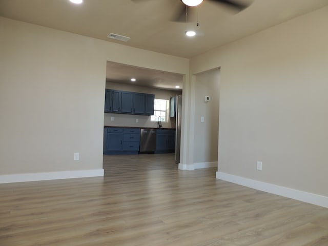 unfurnished living room with ceiling fan, sink, and light wood-type flooring