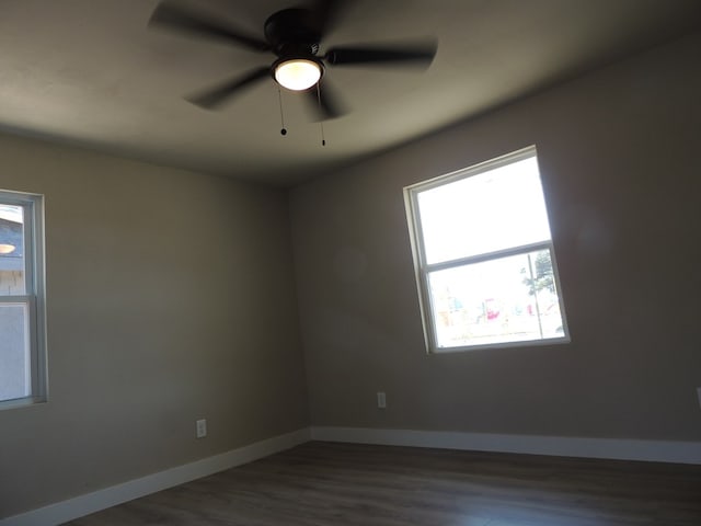 empty room featuring ceiling fan and dark hardwood / wood-style floors