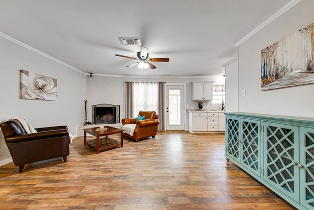 3211 W Shandon Ave, Midland, TX 79705 - living area with ceiling fan, ornamental molding, light wood-style floors, and a fireplace