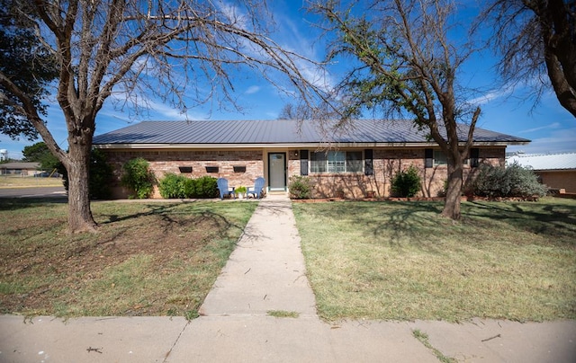 2718 Central Ave, Big Spring, TX 79720 - view of front of property featuring a front yard, a metal roof, and brick siding