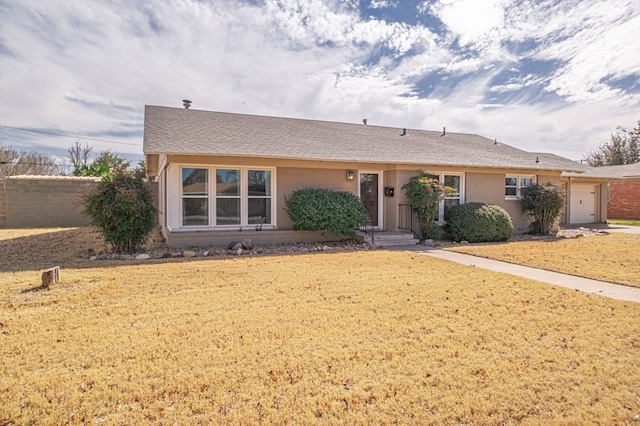 ranch-style home featuring a front lawn and an attached garage