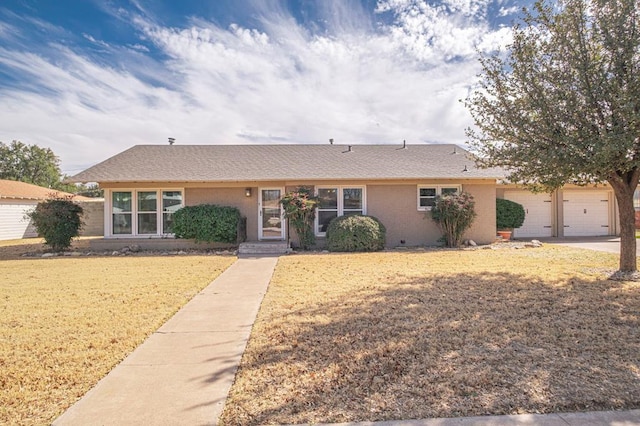 single story home featuring a garage, driveway, and a front yard