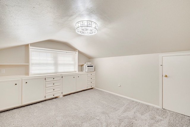 2601 Dengar Ave W, Midland, TX 79705 - additional living space featuring light colored carpet, vaulted ceiling, a textured ceiling, and baseboards