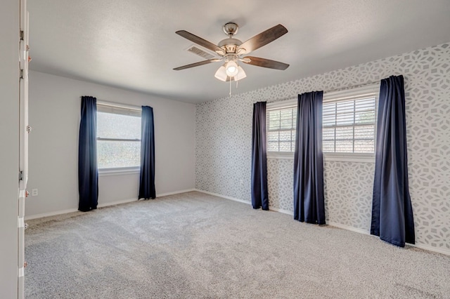 2601 Dengar Ave W, Midland, TX 79705 - spare room with a ceiling fan, wallpapered walls, healthy amount of natural light, carpet flooring, and baseboards