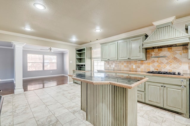 2601 Dengar Ave W, Midland, TX 79705 - kitchen with decorative columns, open floor plan, ceiling fan, decorative backsplash, and gas cooktop