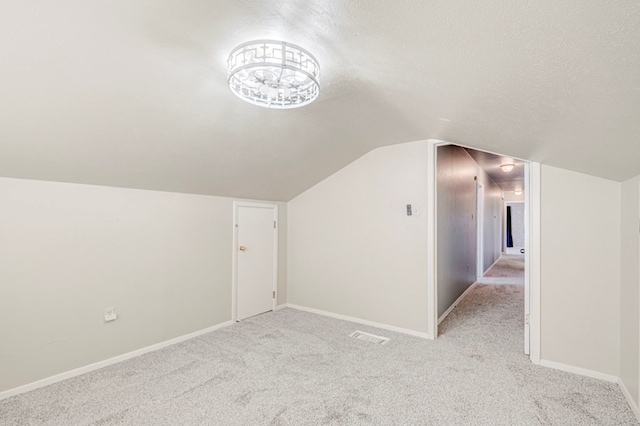 2601 Dengar Ave W, Midland, TX 79705 - additional living space featuring light carpet, a textured ceiling, vaulted ceiling, and baseboards