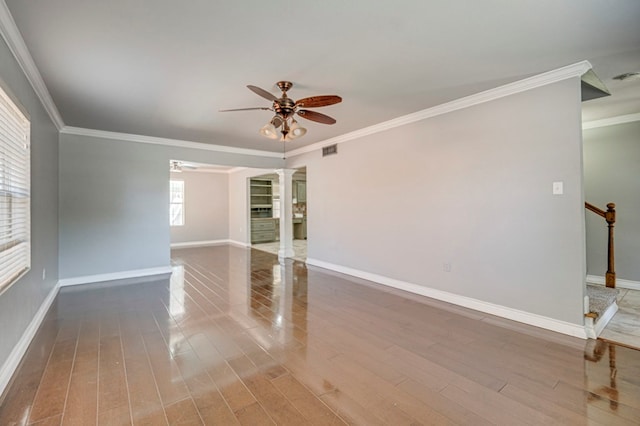2601 Dengar Ave W, Midland, TX 79705 - spare room featuring ceiling fan, ornamental molding, baseboards, ornate columns, and wood finished floors