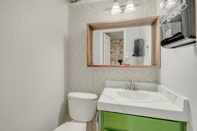 2601 Dengar Ave W, Midland, TX 79705 - bathroom featuring vanity, toilet, and a textured wall