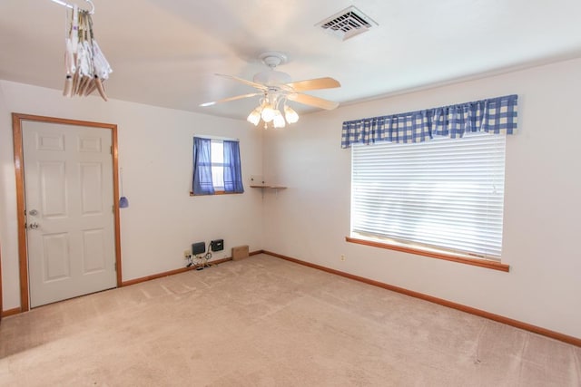 empty room featuring ceiling fan and light carpet