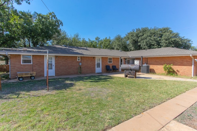 rear view of house featuring a yard, a patio, and central air condition unit