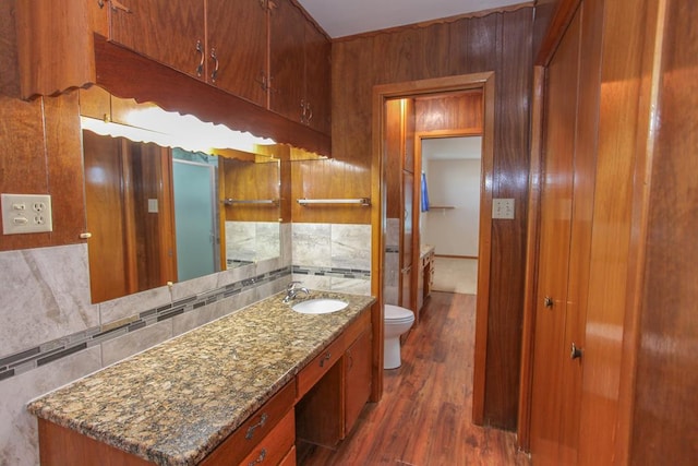 bathroom featuring hardwood / wood-style floors, vanity, tasteful backsplash, and toilet