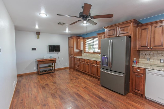 kitchen with dishwasher, dark wood-type flooring, ceiling fan, stainless steel fridge, and light stone countertops