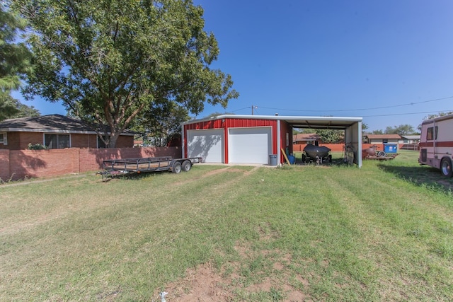 view of yard with a carport, a garage, and an outbuilding