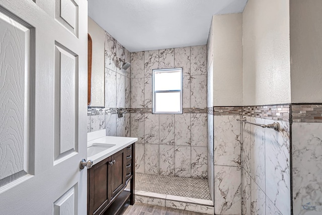 full bathroom featuring a stall shower, wood finished floors, and vanity