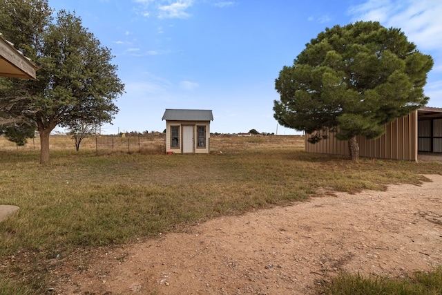 view of yard with a rural view and a storage shed