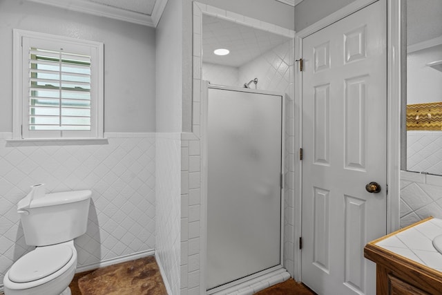 bathroom featuring crown molding, a shower with shower door, and tile walls