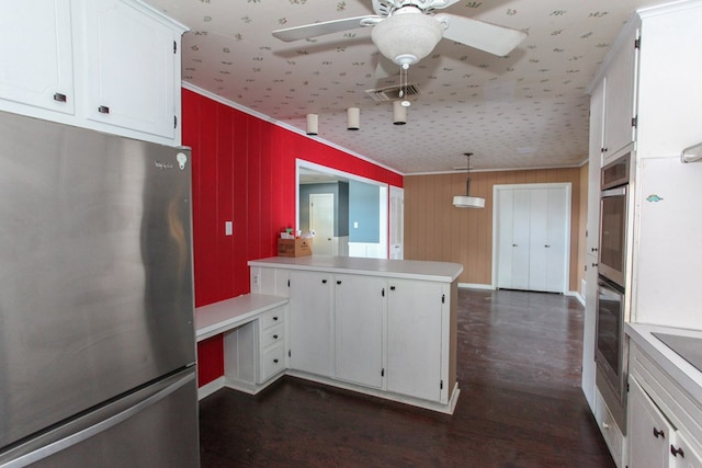 1706 Harvard Ave, Big Spring, TX 79720 - kitchen featuring appliances with stainless steel finishes, a peninsula, a ceiling fan, crown molding, and white cabinetry