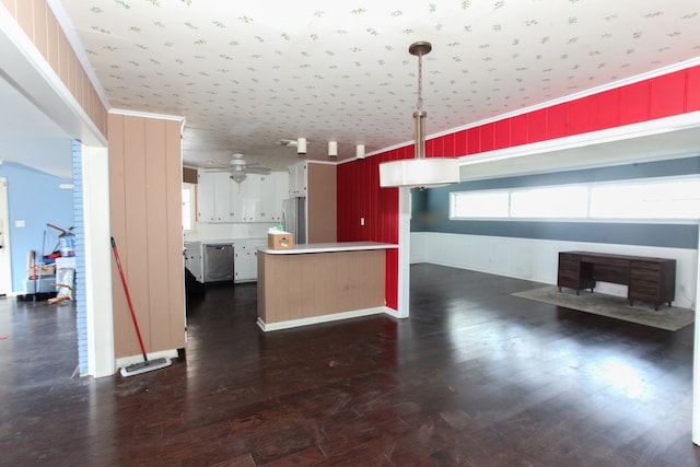 1706 Harvard Ave, Big Spring, TX 79720 - kitchen featuring appliances with stainless steel finishes, light countertops, dark wood-type flooring, hanging light fixtures, and a peninsula