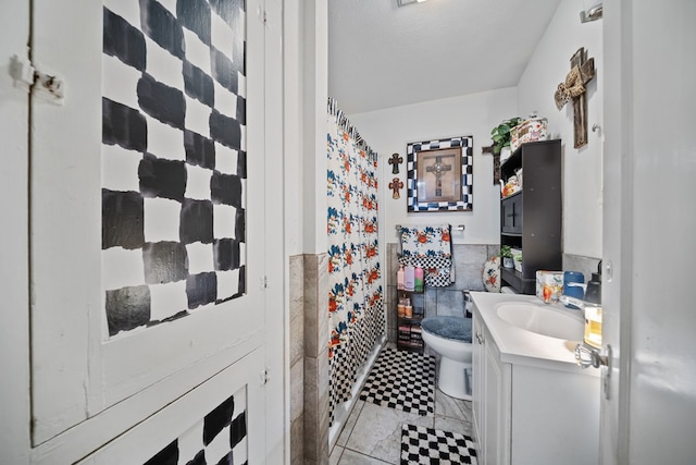 1606 Johnson St, Big Spring, TX 79720 - full bath with vanity, a wainscoted wall, tile walls, and a shower with shower curtain