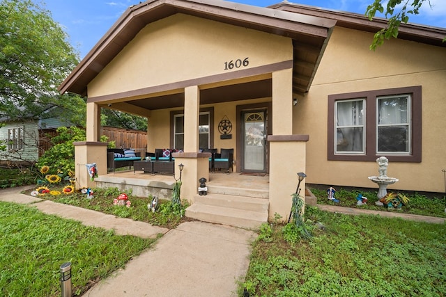 1606 Johnson St, Big Spring, TX 79720 - entrance to property featuring stucco siding, a porch, and outdoor lounge area
