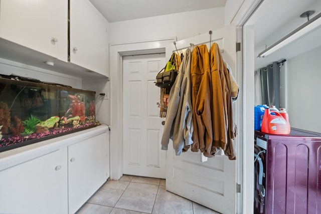 1606 Johnson St, Big Spring, TX 79720 - laundry area featuring washer / clothes dryer, light tile patterned flooring, and cabinet space
