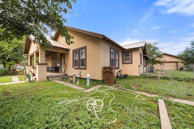 1606 Johnson St, Big Spring, TX 79720 - view of home's exterior featuring stucco siding, a metal roof, a patio area, and a gate