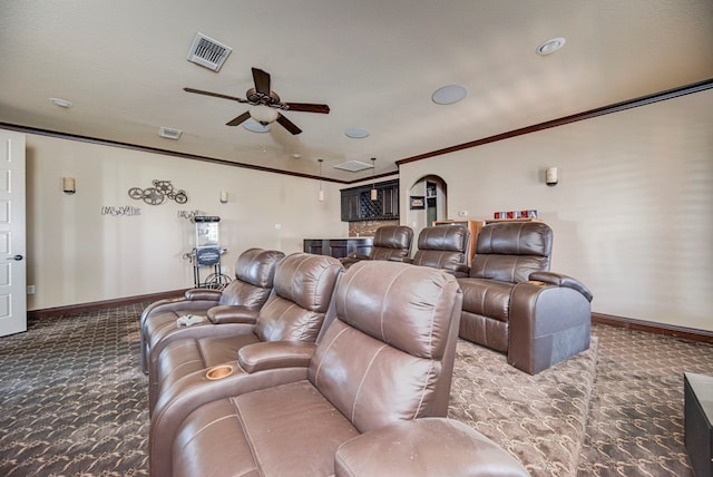 cinema room with crown molding, ceiling fan, a textured ceiling, and dark colored carpet