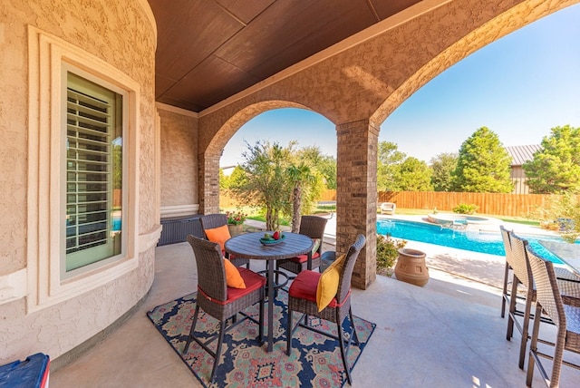 view of patio / terrace with a pool with hot tub